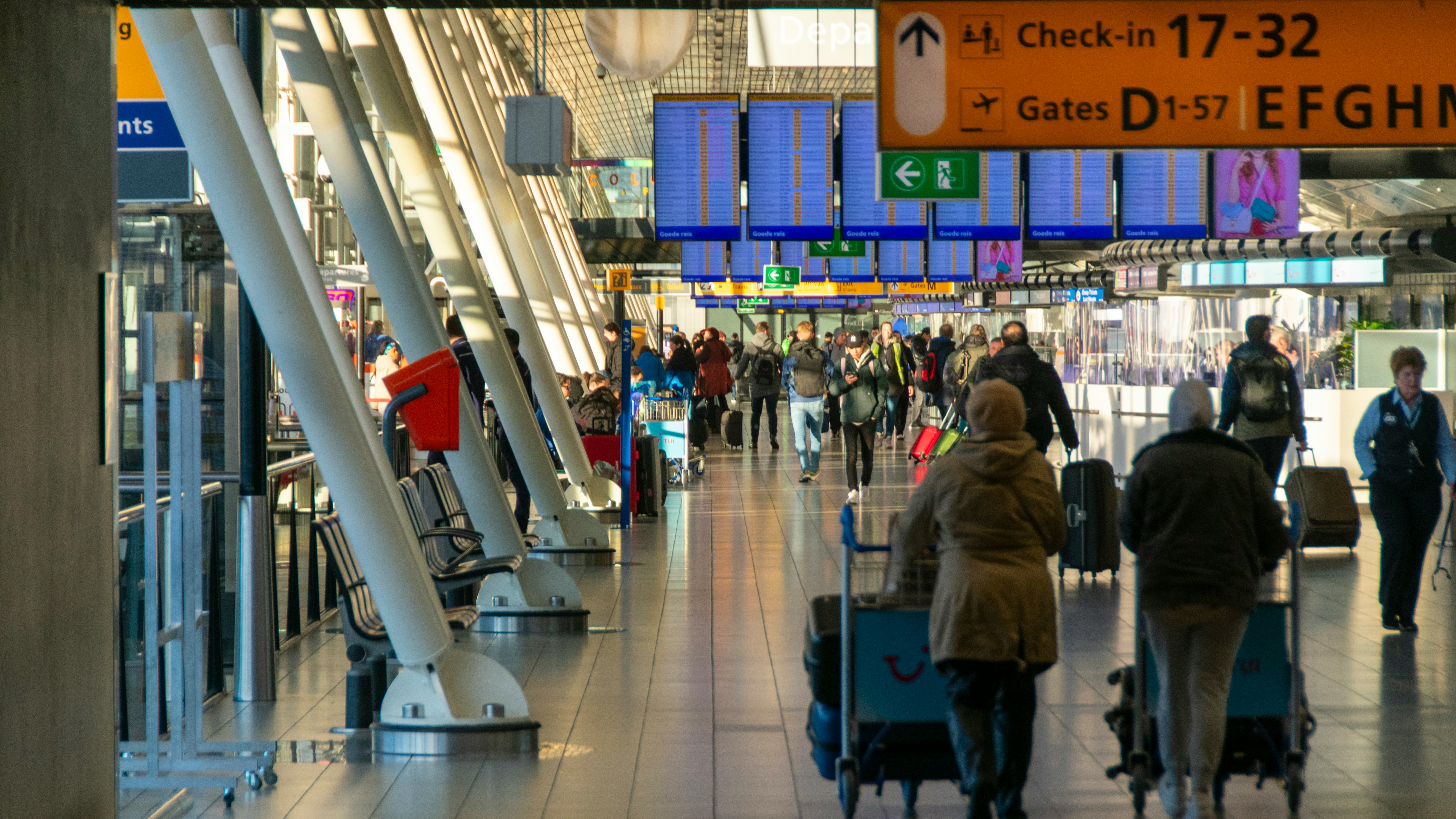 Busy airport terminal with travellers gathered around the food court during a peak travel period.